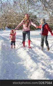 Mother Walking With Children Through Snowy Landscape