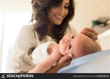 Mother washing a newborn baby in a bath tub