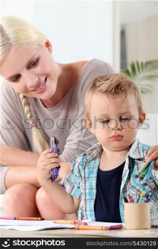 mother watching her little son drawing