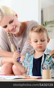 mother watching her little son drawing