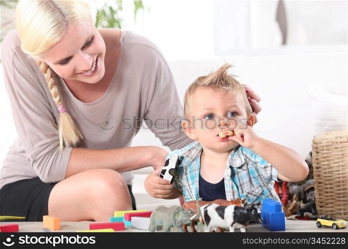 Mother watching son playing with toys
