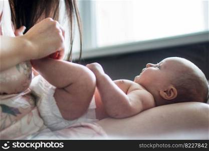 mother with a baby on a bed by the window