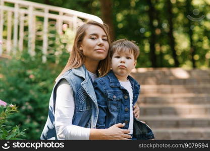 Mother with a three-year-old child playing outdoors on a sunny day in a city park