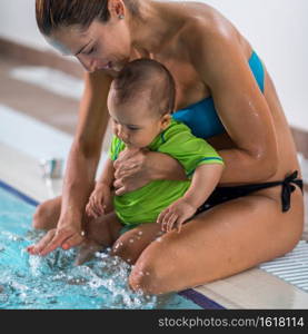 Mother with baby boy in the swimming pool on swimming class