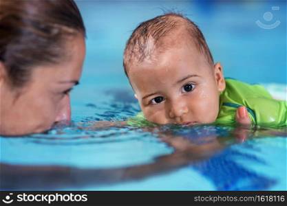 Mother with baby boy in the swimming pool on swimming class