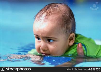 Mother with baby boy in the swimming pool on swimming class