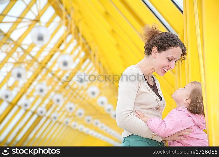 mother with baby on yellow bridge