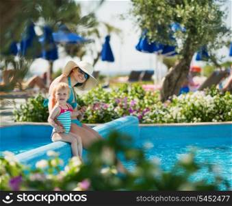 Mother with baby sitting in open air pool