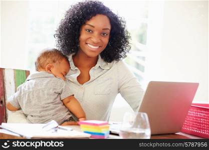 Mother With Baby Working In Office At Home