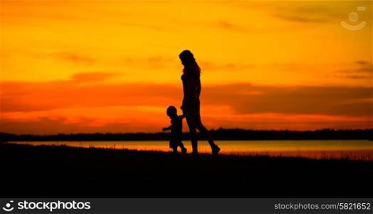 Mother with child looking at the beautiful sunset