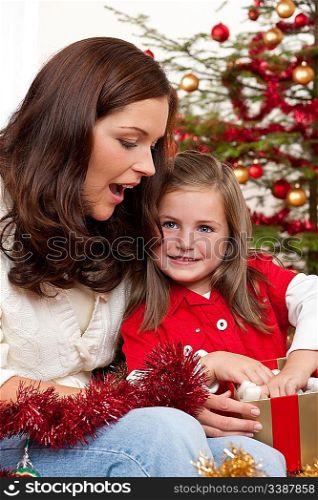 Mother with child opening present on Christmas