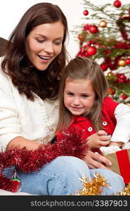 Mother with child opening present on Christmas