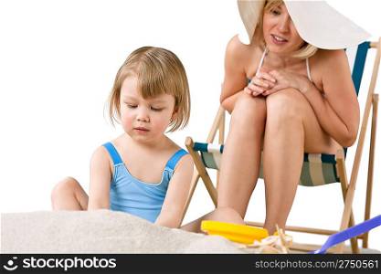 Mother with child playing with beach toys on sand