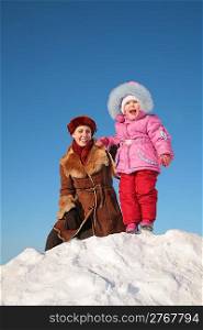 mother with child stand on snow hill