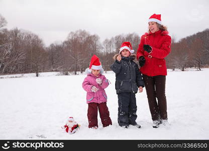 Mother with children burn bengal fires in park in winter