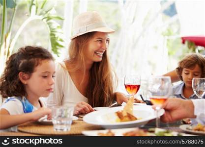 Mother With Children Enjoying Meal In Restaurant