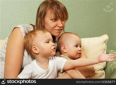 Mother with children on a green background watch TV