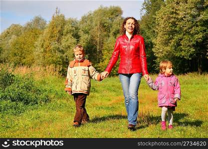 Mother with children on walk in wood, front view