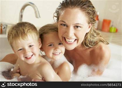 Mother With Children Relaxing In Bubble Filled Bath