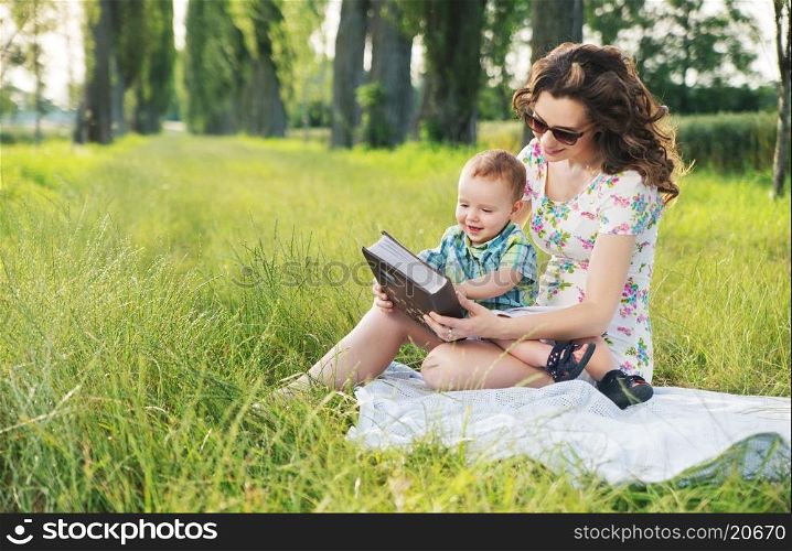 Mother with curly hairstyle reading fairy tales for cute baby