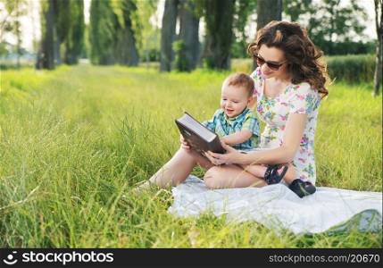 Mother with curly hairstyle reading fairy tales for cute baby