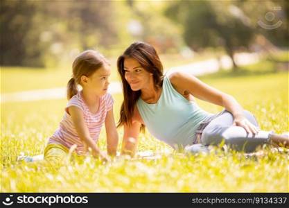 Mother with cute little daughter having fun in park on a sunny day