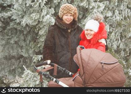 mother with daughter and a carriage on a winter walk.