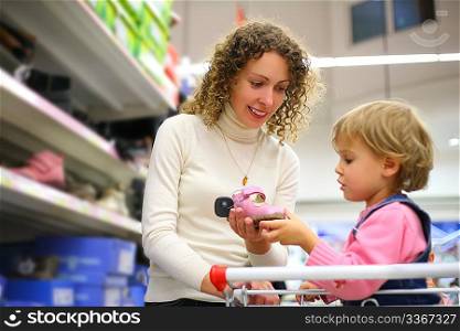 Mother with daughter choose footwear in shop