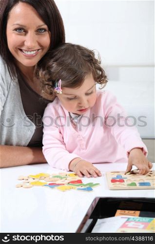 Mother with daughter doing puzzle