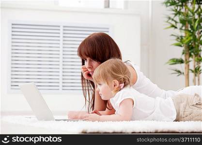Mother with daughter looking on the laptop
