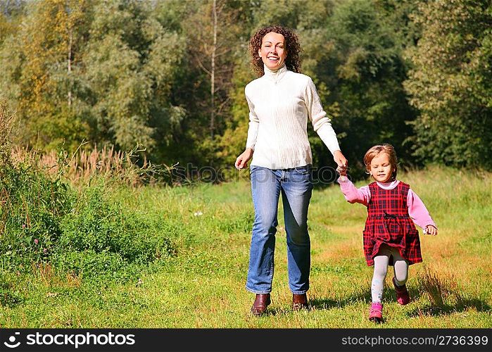 Mother with daughter running in wood, front view
