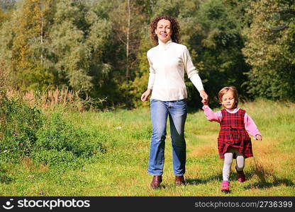 Mother with daughter running in wood, front view
