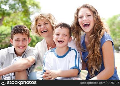 Mother with grown up daughter and son in the park smiling and having fun