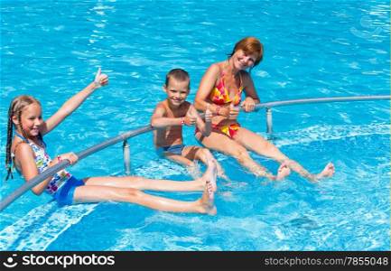 Mother with her children in the summer outdoor pool.