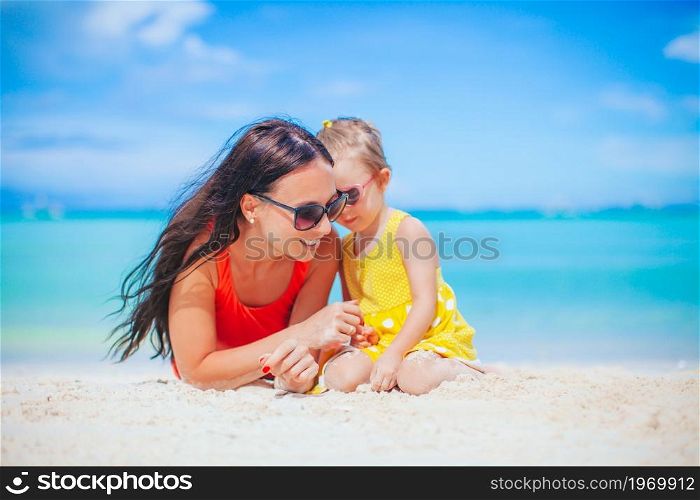 Mother with her cute daughter on summer beach vacation. Beautiful mother and daughter at the beach enjoying summer vacation