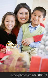 Mother With Her Daughter And Son Holding Christmas Gifts