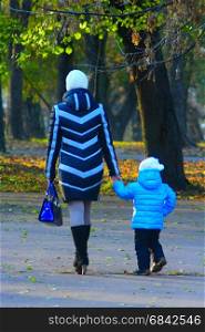 Mother with her daughter go in the park. Mother with her daughter go in the autumnal park