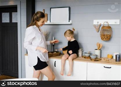 Mother with her daughter in the kitchen cooking together