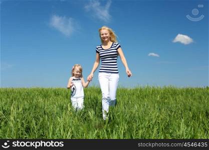 mother with her daughter outdoors in summer day