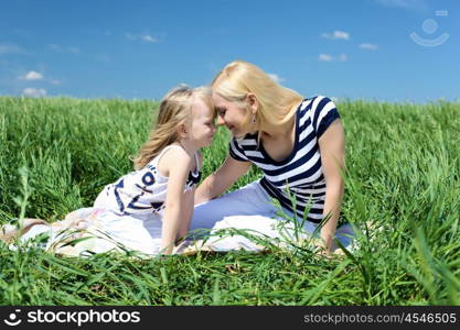 mother with her daughter outdoors in summer day