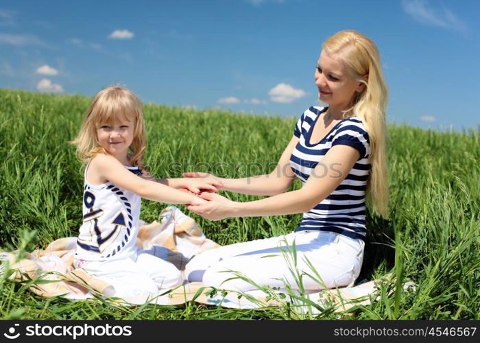 mother with her daughter outdoors in summer day