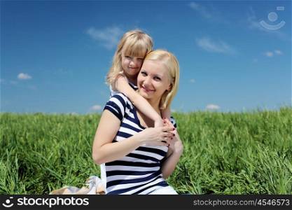 mother with her daughter outdoors in summer day