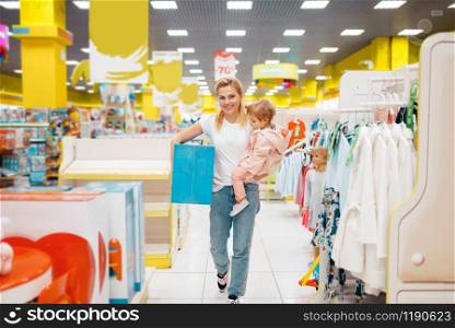 Mother with her little daughter have a purchase in kids store. Mom and child buying toys in supermarket together, family shopping