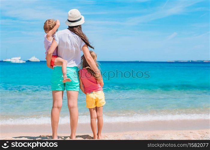 Mother with her little daughters on the beach. Beautiful mother and daughter on the beach