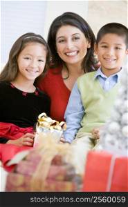 Mother With Her Son And Daughter Holding Christmas Gifts