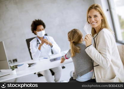 Mother with his little daughter at the pediatrician examination by African american female doctor