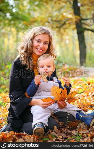 Mother with son in forest in autumn