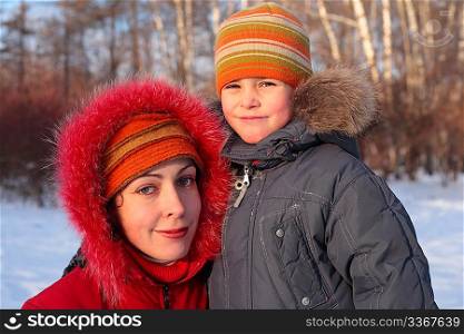 Mother with son in wood in winter