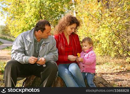 mother with the daughter and the grandfather in the park in autumn 2