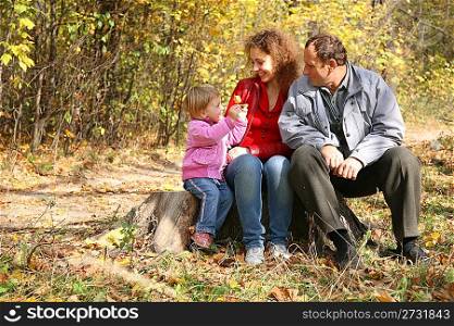 mother with the daughter and the grandfather in the park in autumn